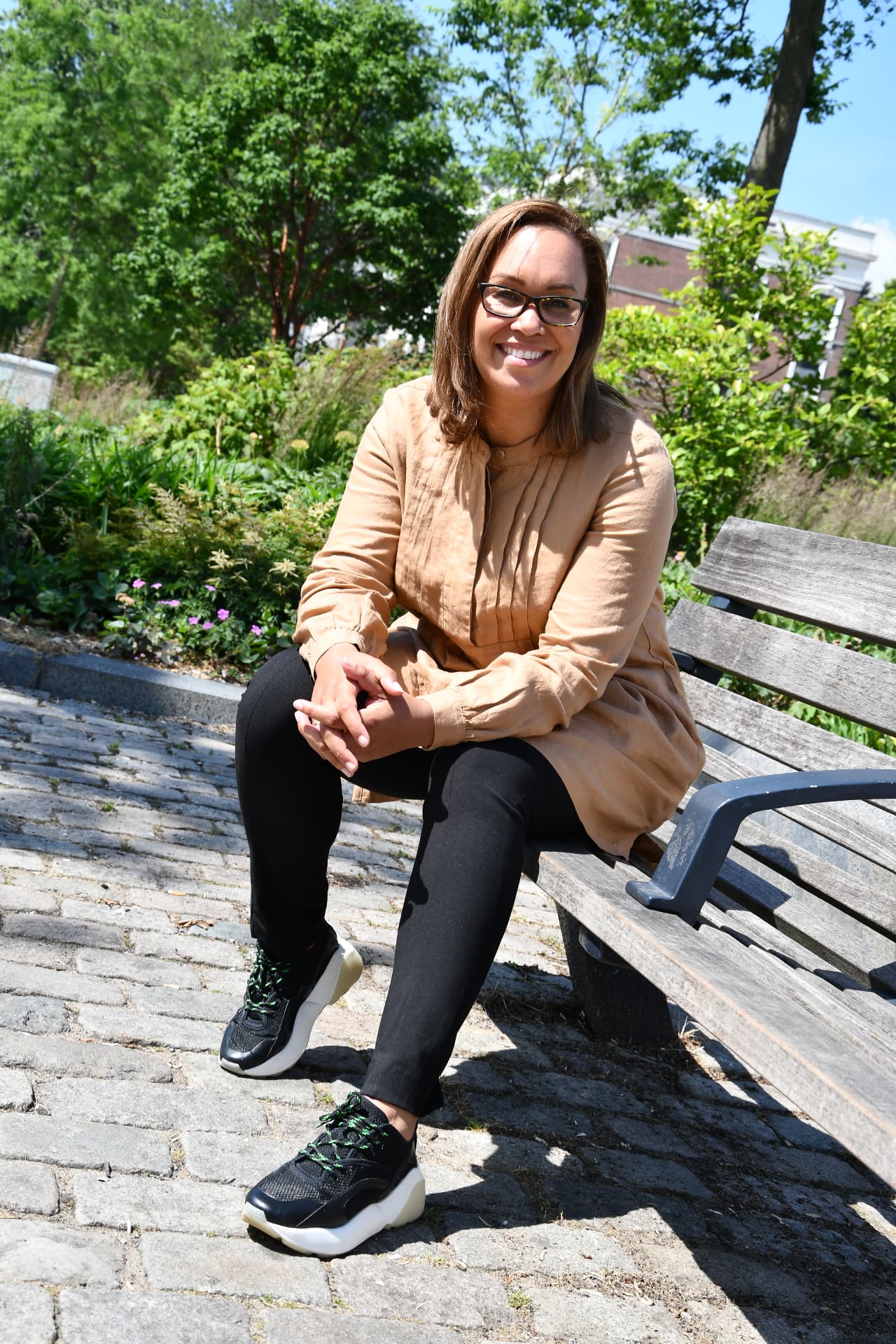 Portret van Sharon Plet, ontwikkelaar van de GEO methodiek, zittend in een park